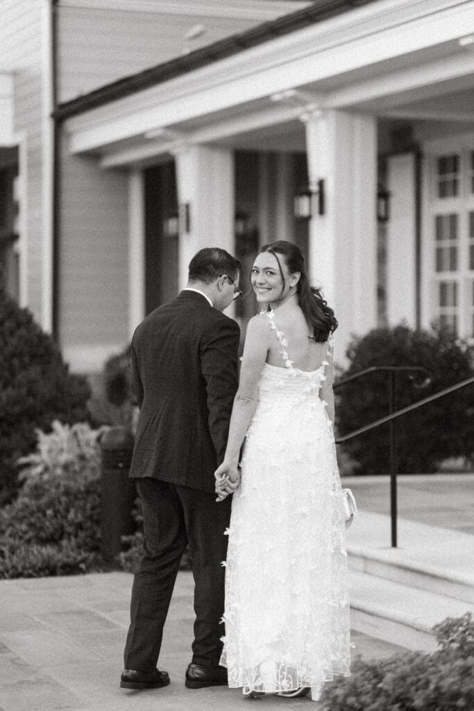 Bride and groom share a quiet moment outside a classic Southern venue, captured in black and white by a Charleston SC wedding photographer.