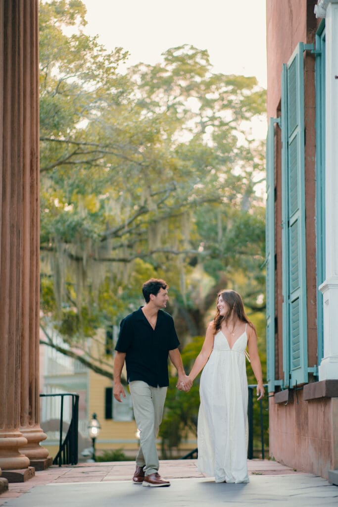 Couple holding hands along a historic Charleston street, capturing the romance of eloping in Charleston, SC